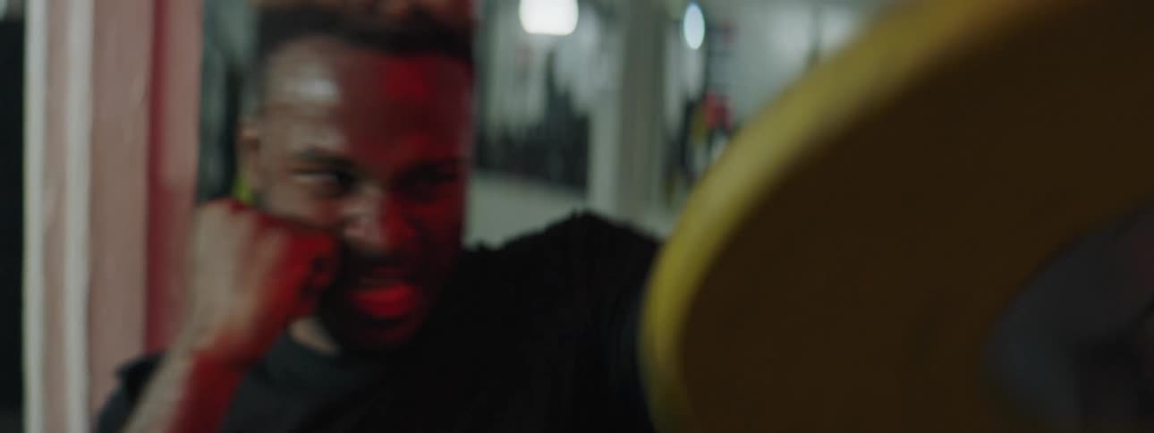 A man in a gym exercising by lifting weights