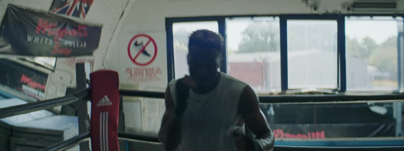 A man is training for boxing indoors during the day