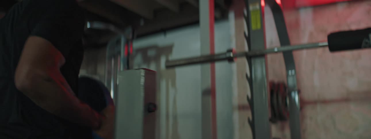 A gym goer grabs a weight to add to a weightlifting bar