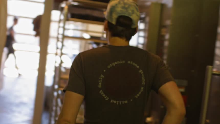 People are working and walking in a kitchen