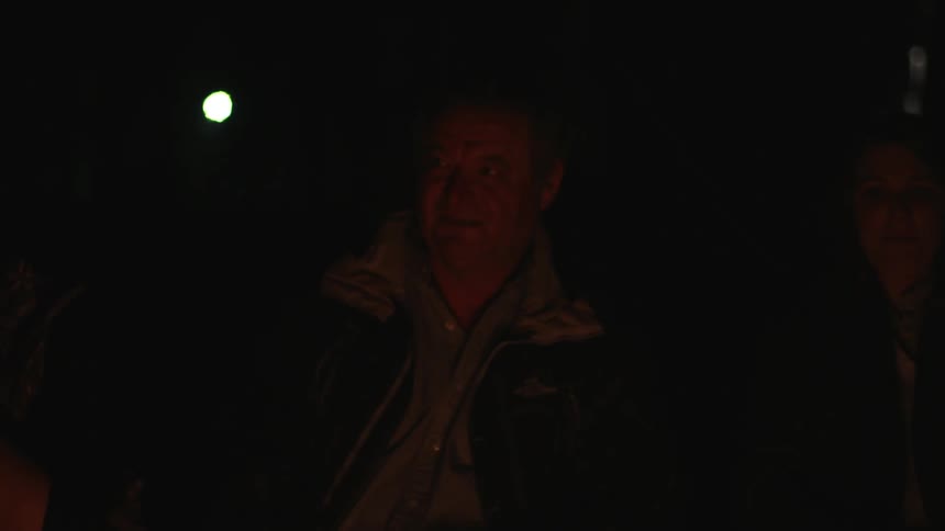A man is lit partially by a campfire