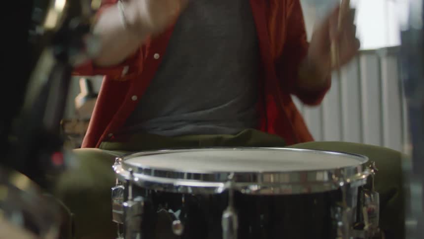 A man is drumming outdoorsat night