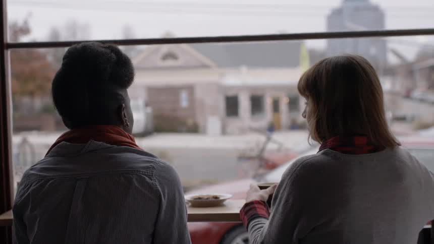 Women sitting at a window counter while chatting