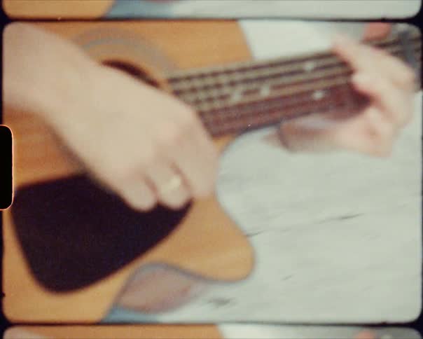 A woman on a rooftop playing a guitar
