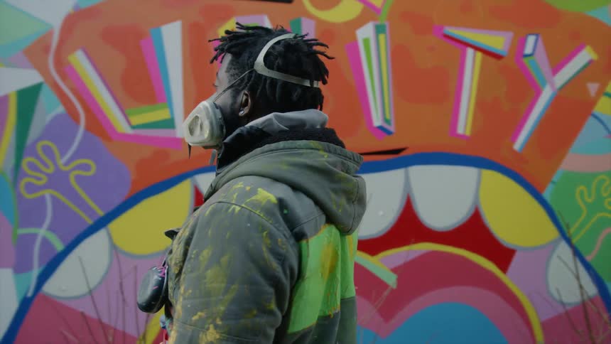 A man is walking by a wall that is painted