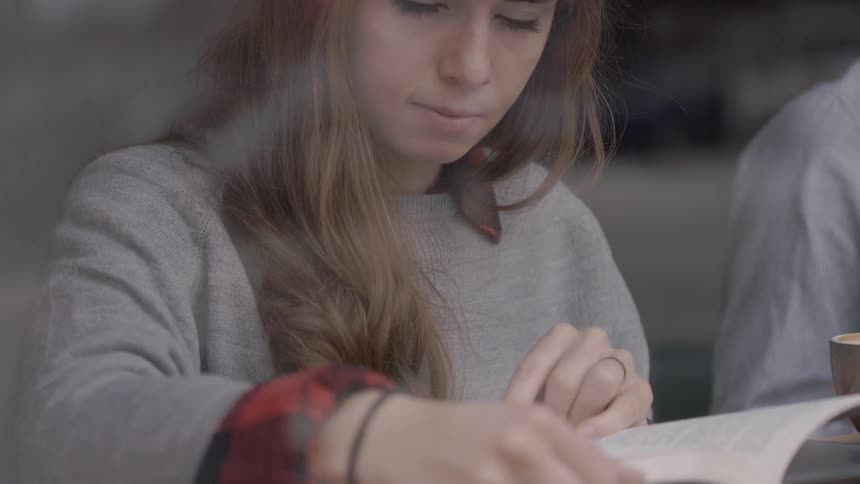 A woman with bangs reads a menu