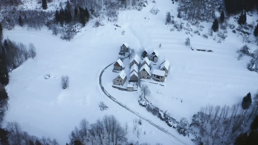 A village covered in snow surrounded by trees