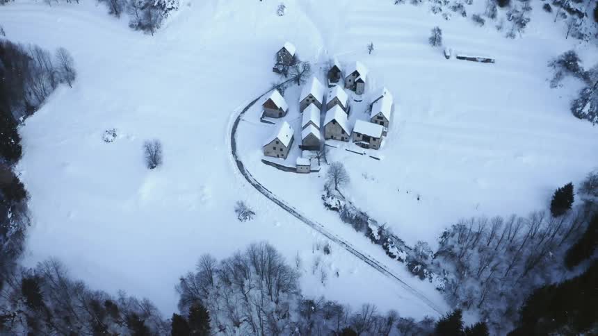 Buildings in a snow covered field in a rural area