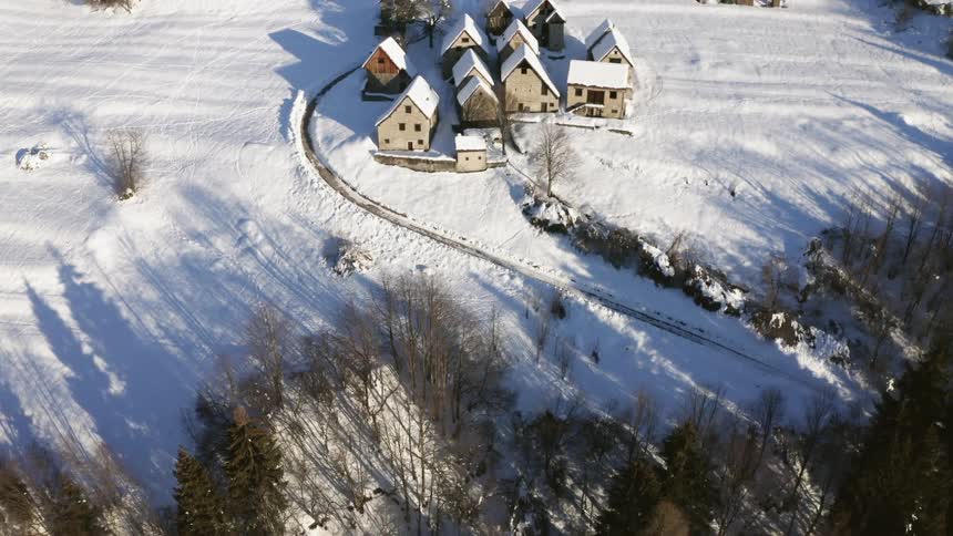 An aerial view of a house in winter is displayed