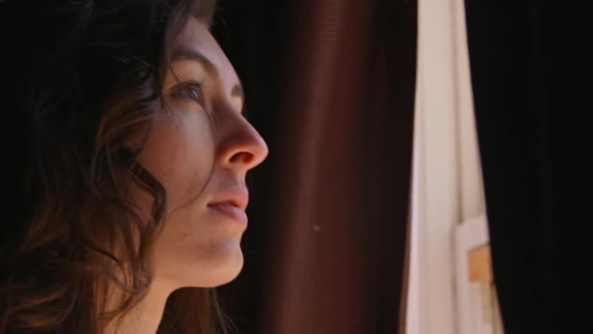 A woman is looking out of a window