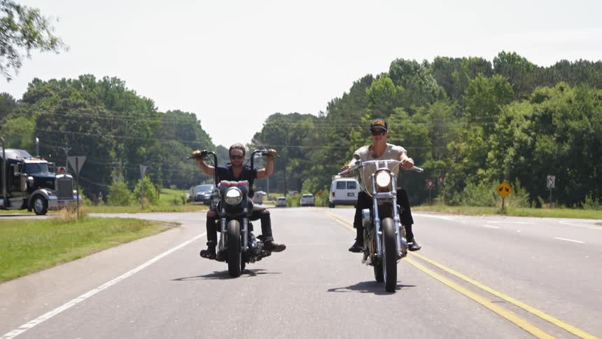 Two motorcycles are driving down a road