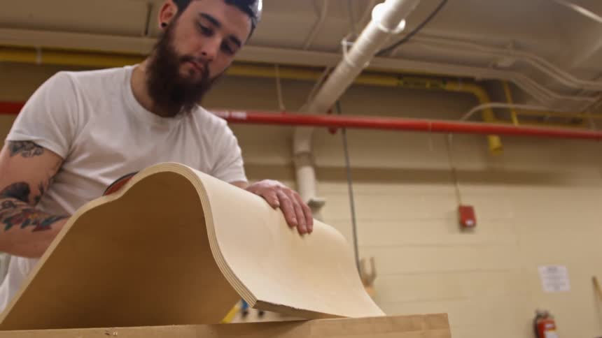 A man smooths a piece of wood