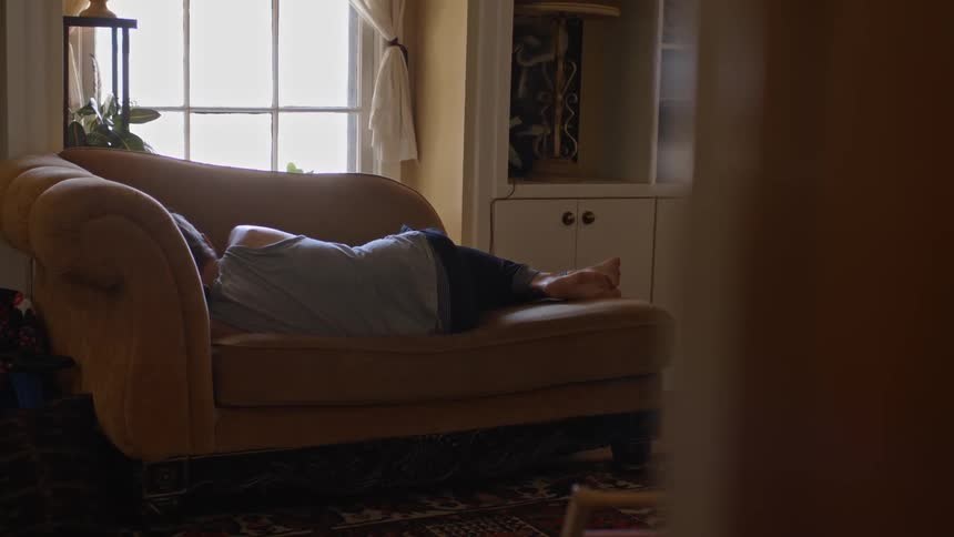 A man is sleeping on a couch