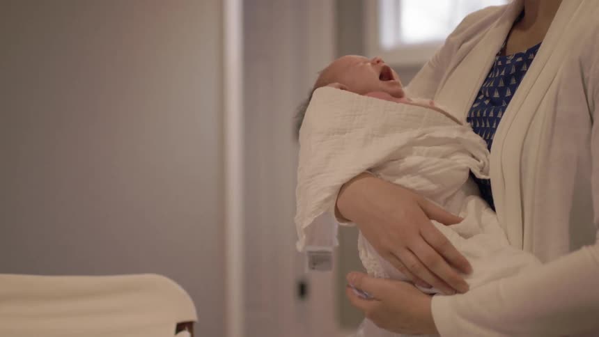 A woman holding a crying baby