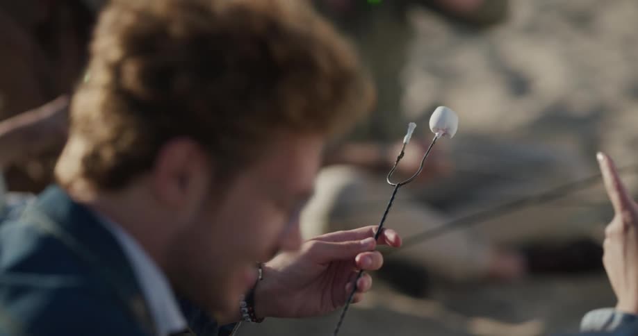 People are roasting marshmallows at the beach