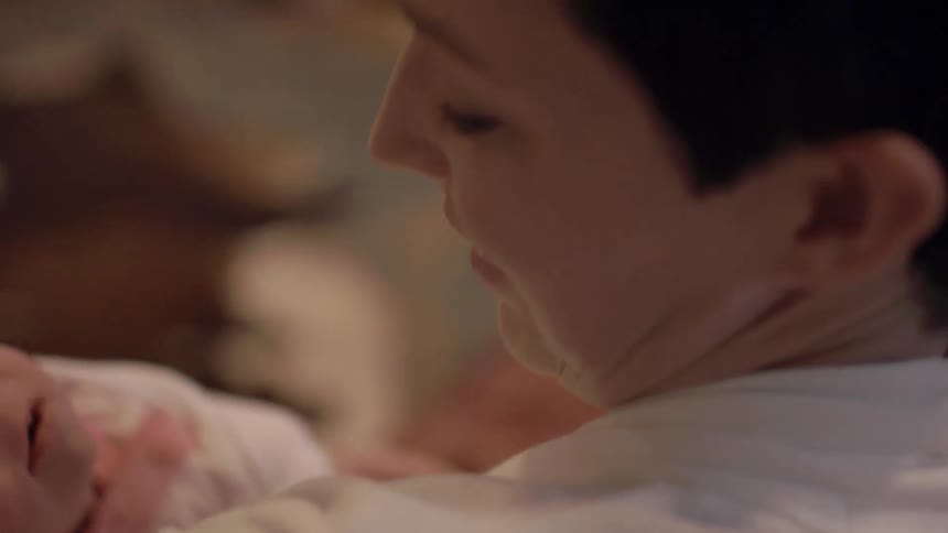 A woman cradles a newborn