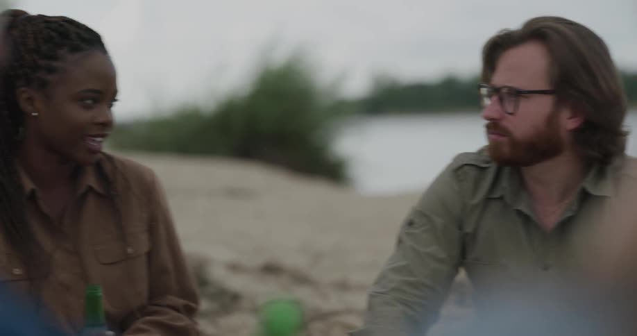 Friends sit on the beach talking