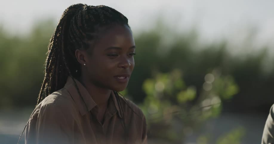 Young black woman smiling and talking while sitting outside