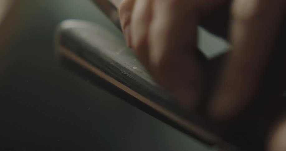 A person sanding a knife handle on a knife