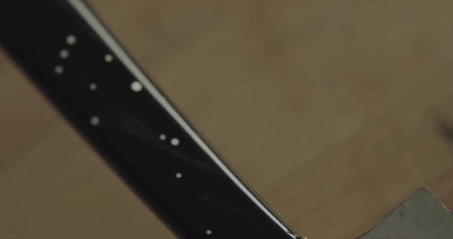 A person in a room wiping the handle of a knife