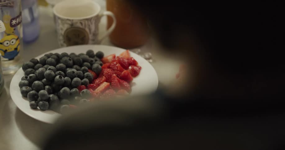 A child grabbing and eating a piece of fruit