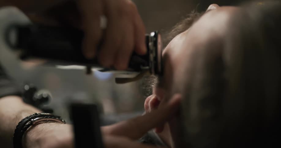 A barber shaving a persons face