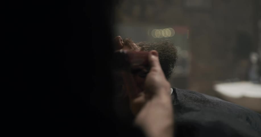 A barber trims a mans beard