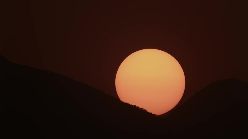 Sun setting between mountains