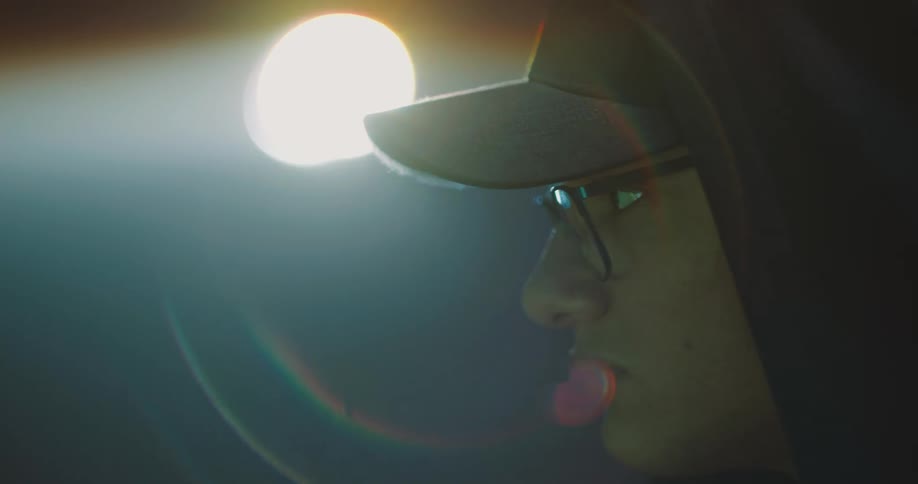 A man in a room with a hat glasses and a hoodie
