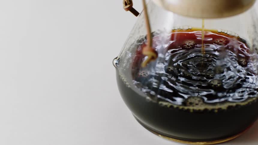 Coffee flowing thorough a filter into a glass