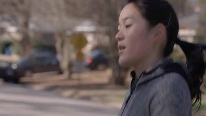 A woman jogging along a residential street