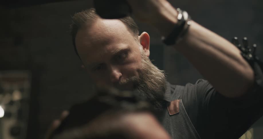 A barber talks as he combs a mans hair