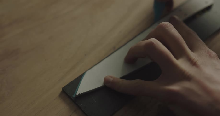 Hands trace the pattern of a knife onto a piece of metal
