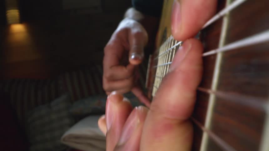 A man plays the acoustic guitar at home