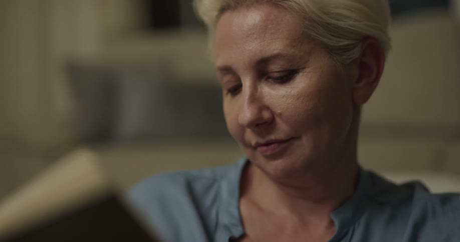 A woman sitting in a room reading a book