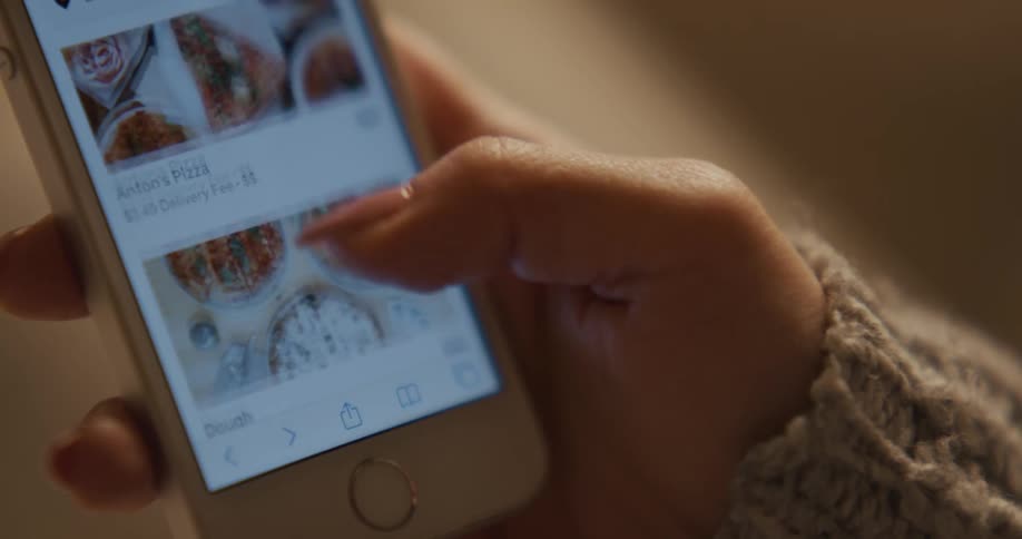 A woman scrolls on her cell phone
