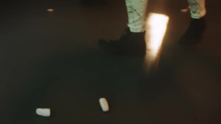 A person is dancing indoors while lights are flashing