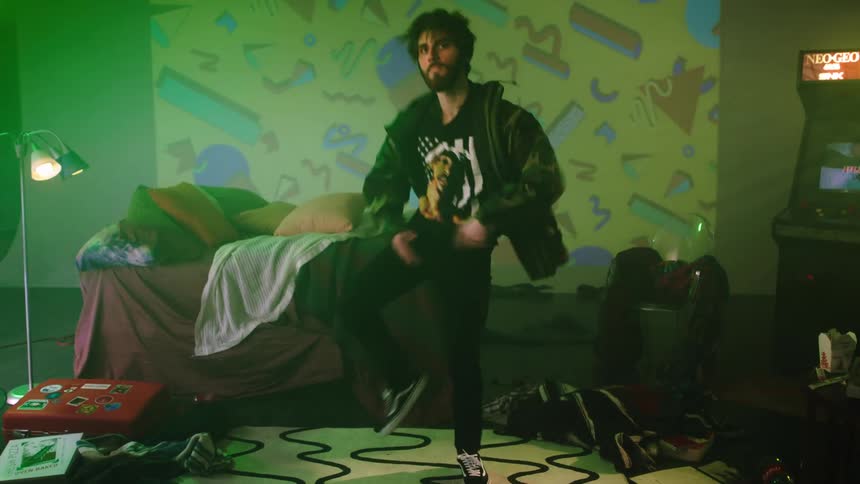 A man in a room dancing with a lamp and a arcade in the background