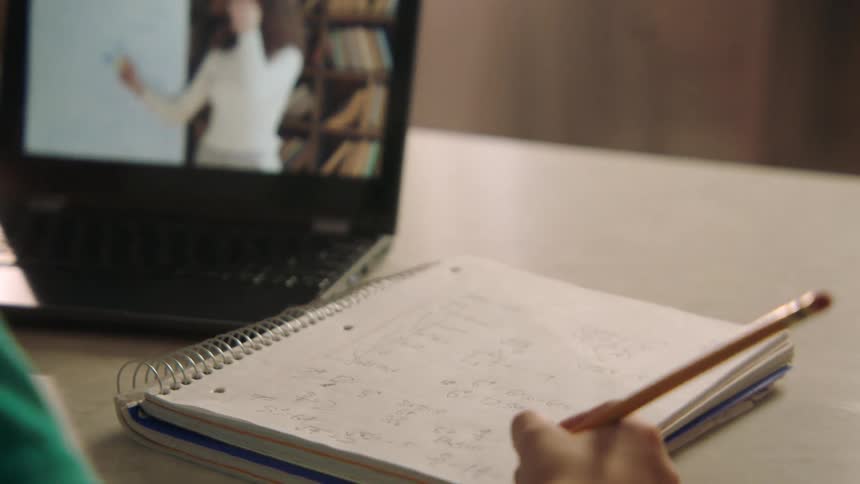 A child taking notes during a video call