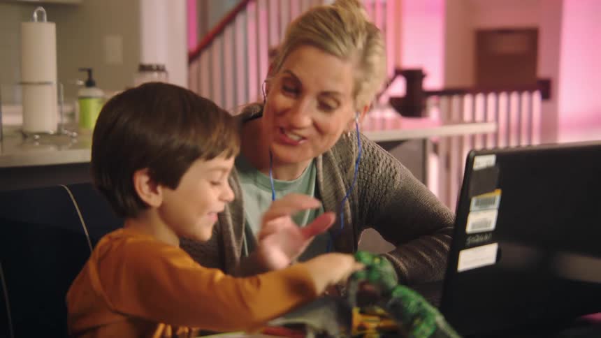 A mother and son use the laptop together