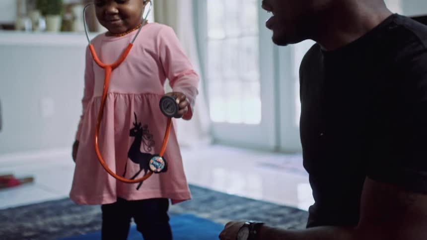 A father and daughter playing with a stethoscope