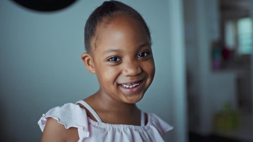 Black girl smiling and laughing inside her house