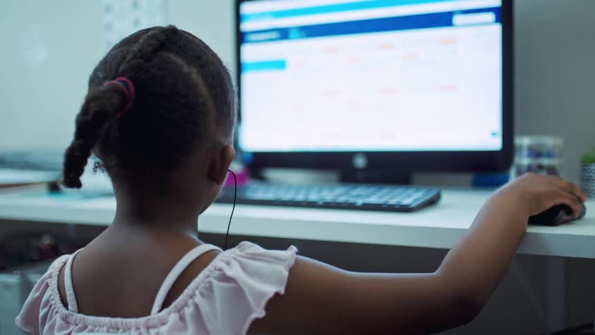 A child sitting at a computer and talking