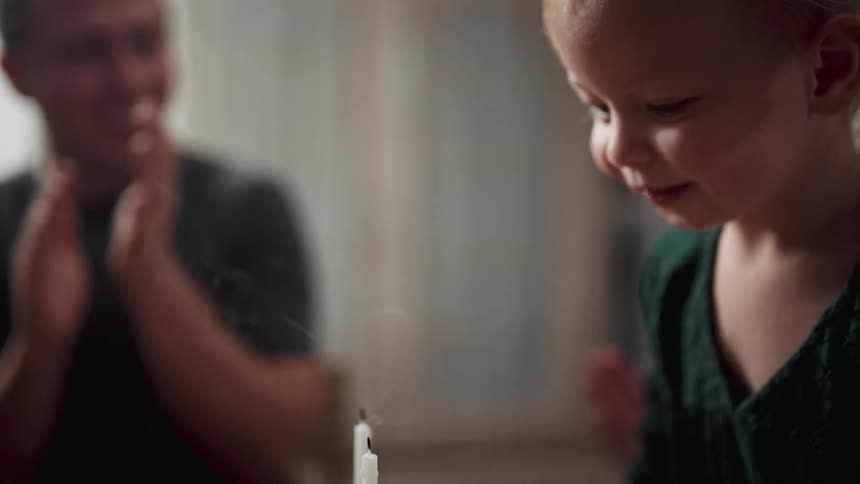 Kids blowing out candles on a cake