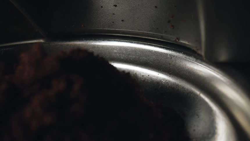 Coffee grounds falling into a cylinder