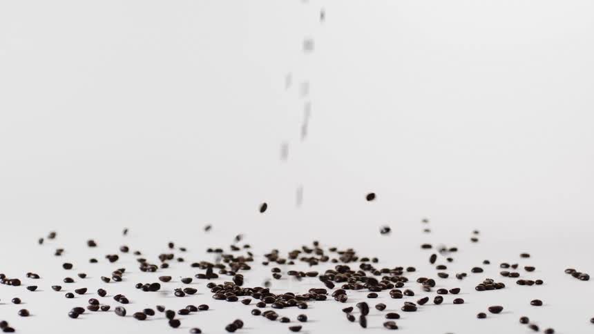 Coffee beans falling onto table and bouncing around