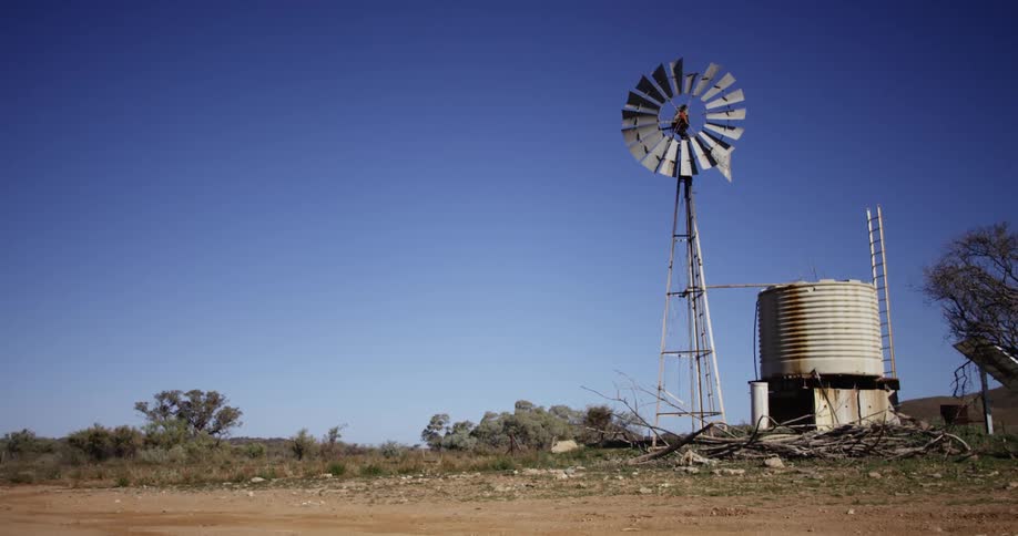 Wind turbine and an old silo in a rural area and a clear sky