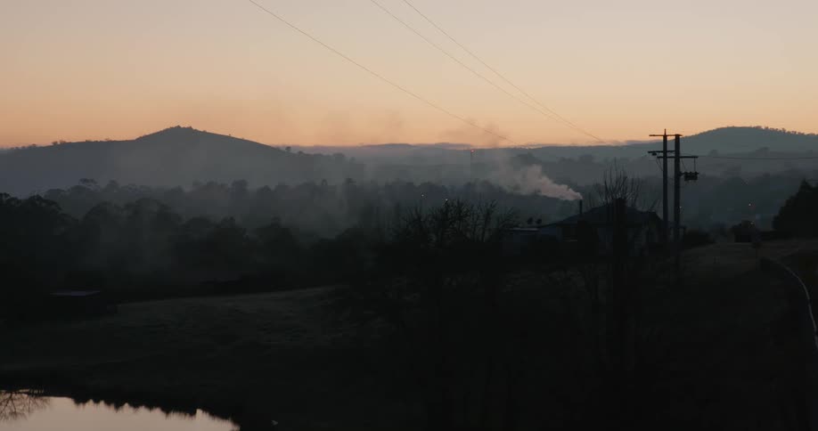 Smoke rises from the chimney at sunrise