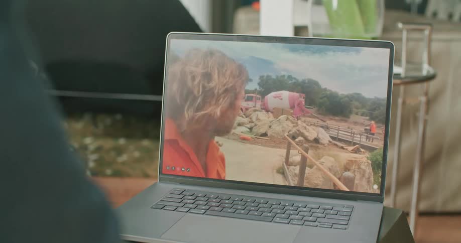 Man video calling a construction worker on his laptop while the construction worker shows the construction site