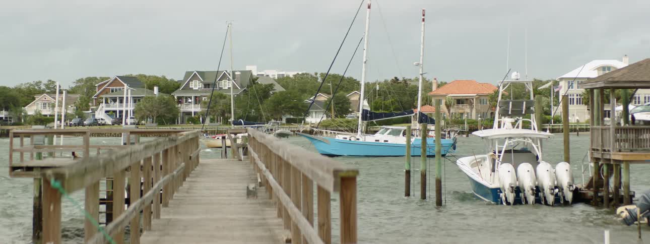 The boats are all docked by the shore